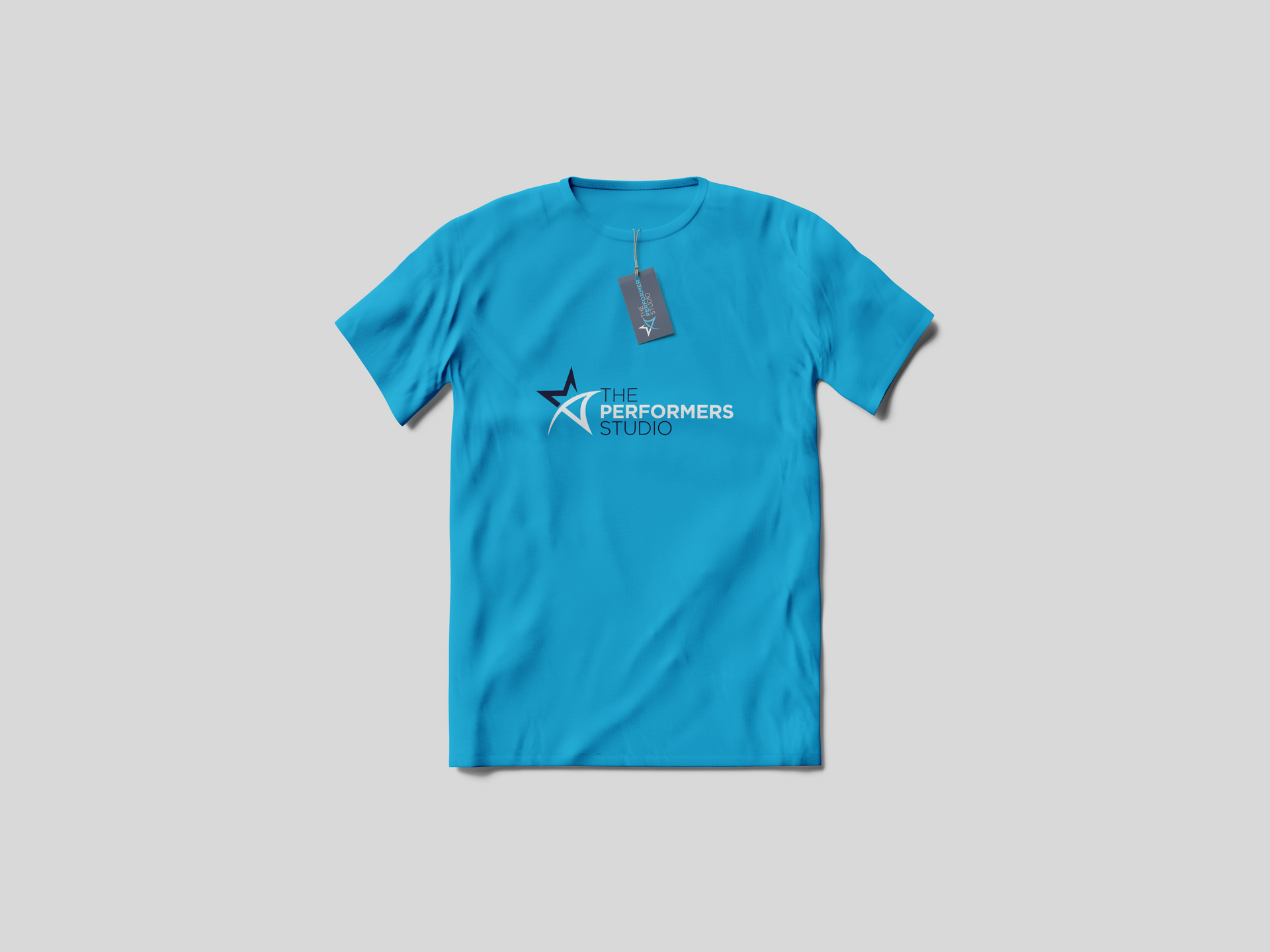 Blue t-shirt with logo and attached tag, centered on a light gray background.