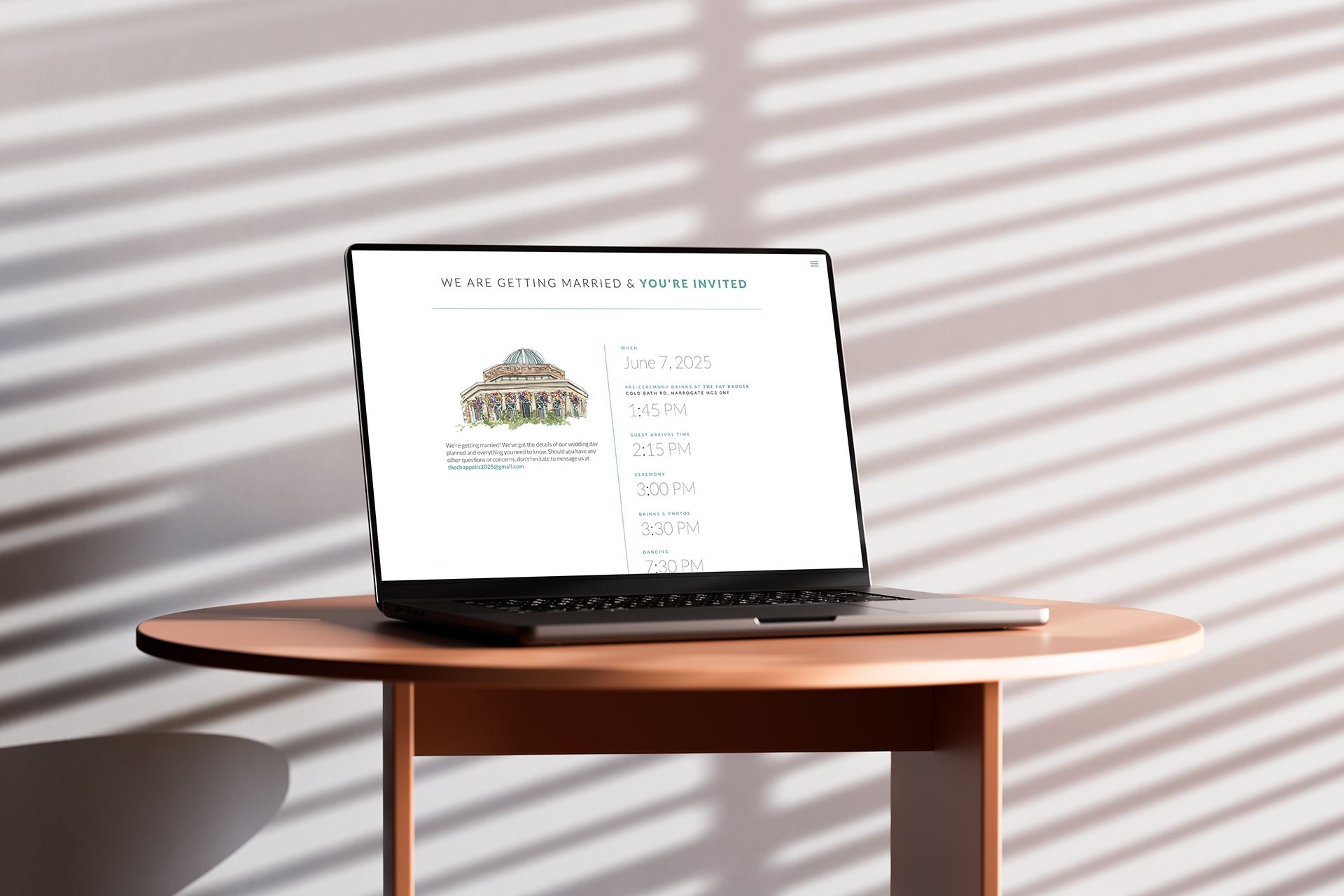 Laptop displaying a website with building sketch on a round table, lit by sunlight through blinds.