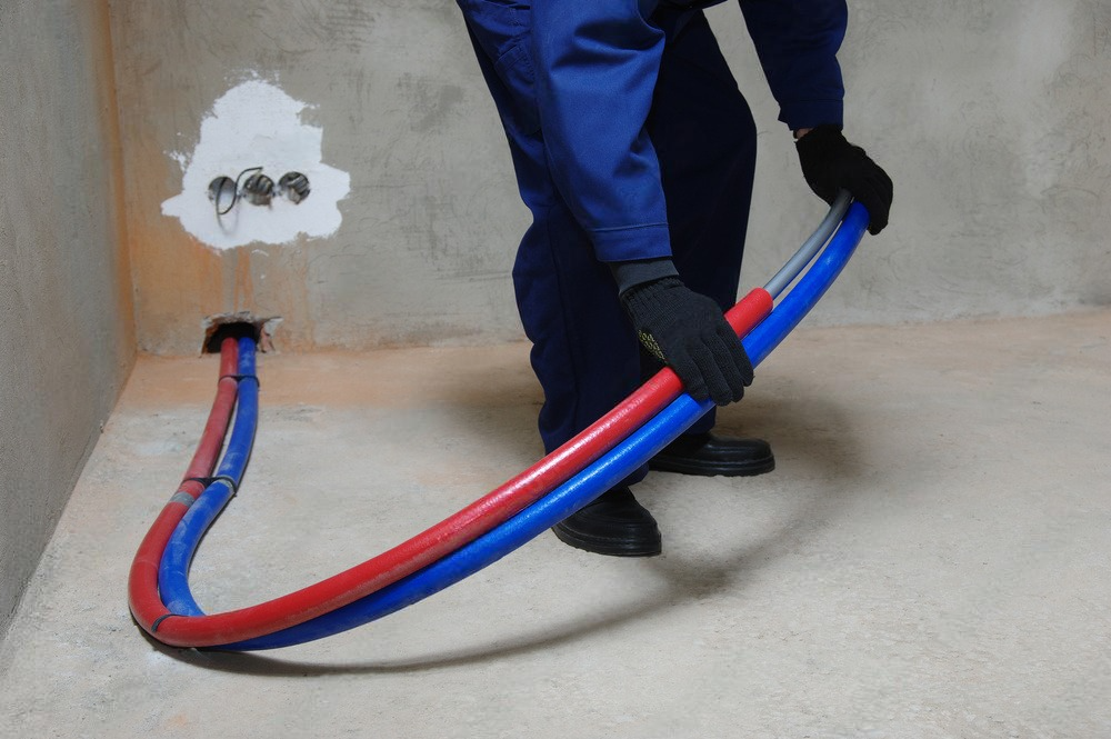 a man wearing black gloves is holding a red and blue pipe