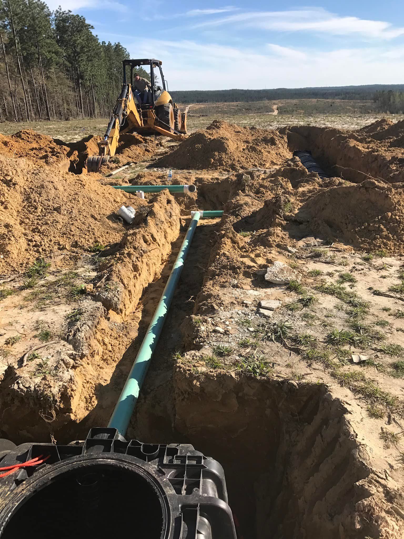 A pipe is being installed in a hole in the ground.