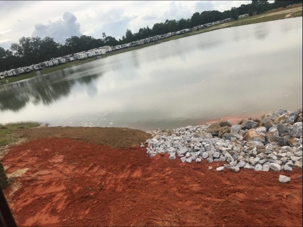 A large body of water surrounded by rocks and dirt