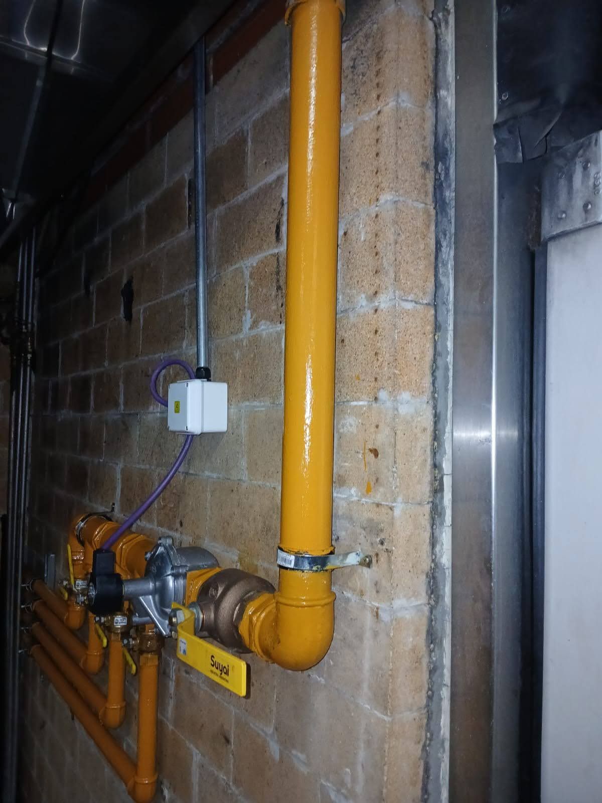 Primer plano de los reguladores del tanque de oxígeno con componentes azules y dorados y manómetros.