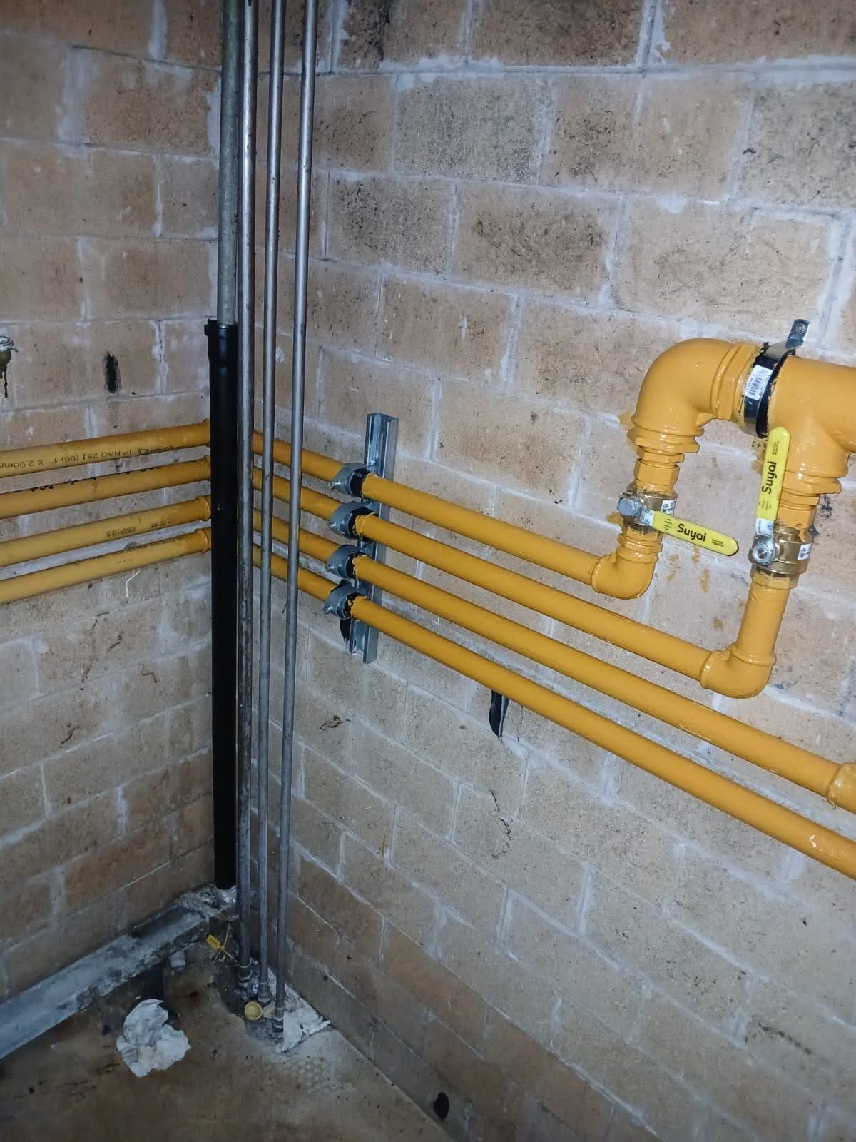 Persona ajustando una válvula roja en un sistema de bomba de agua.