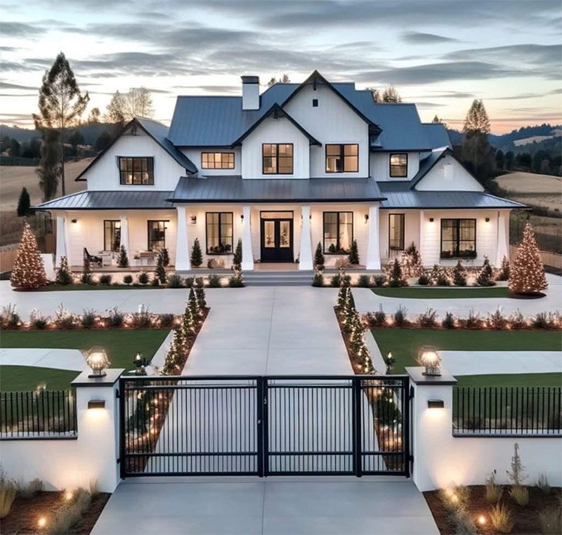 A large house with a driveway leading to it is surrounded by trees.