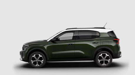 Un SUV vert avec un toit blanc est assis sur une surface blanche.