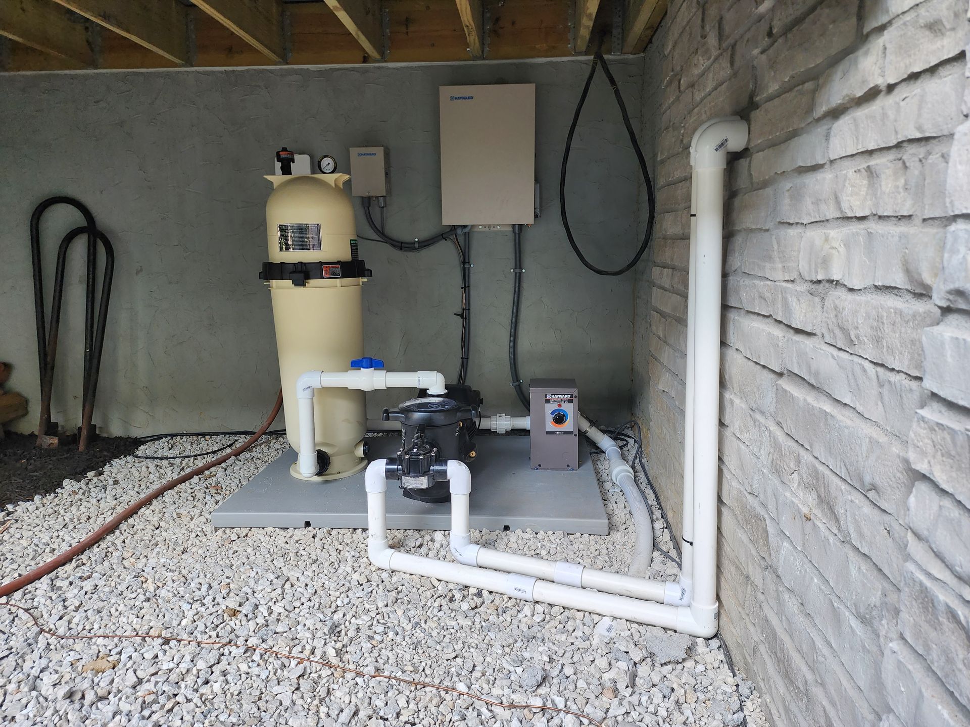 A swimming pool filter is attached to a brick wall