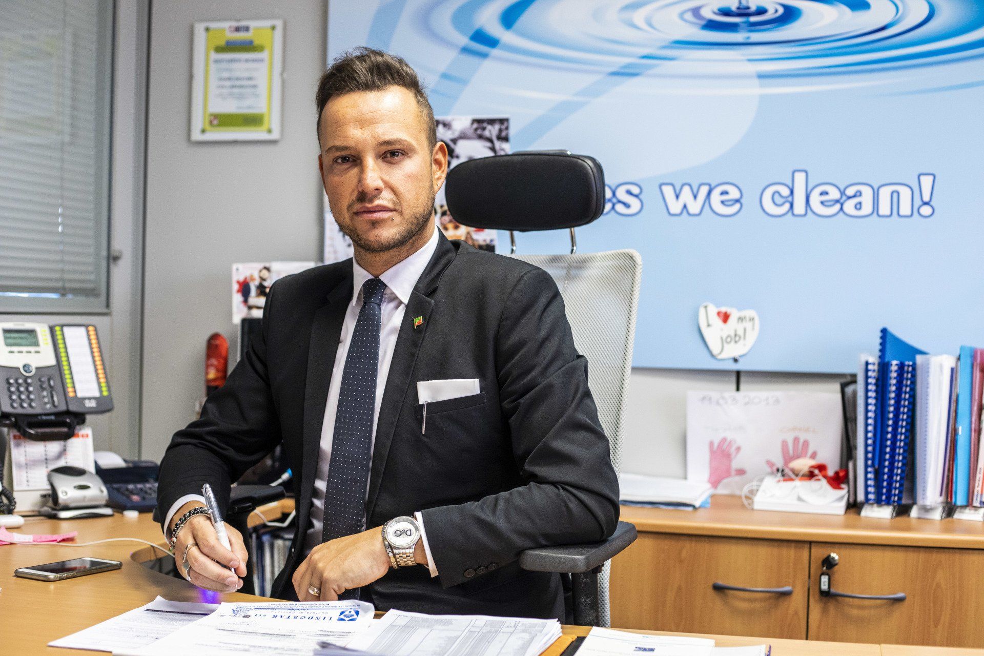 Un uomo in giacca e cravatta è seduto a una scrivania.