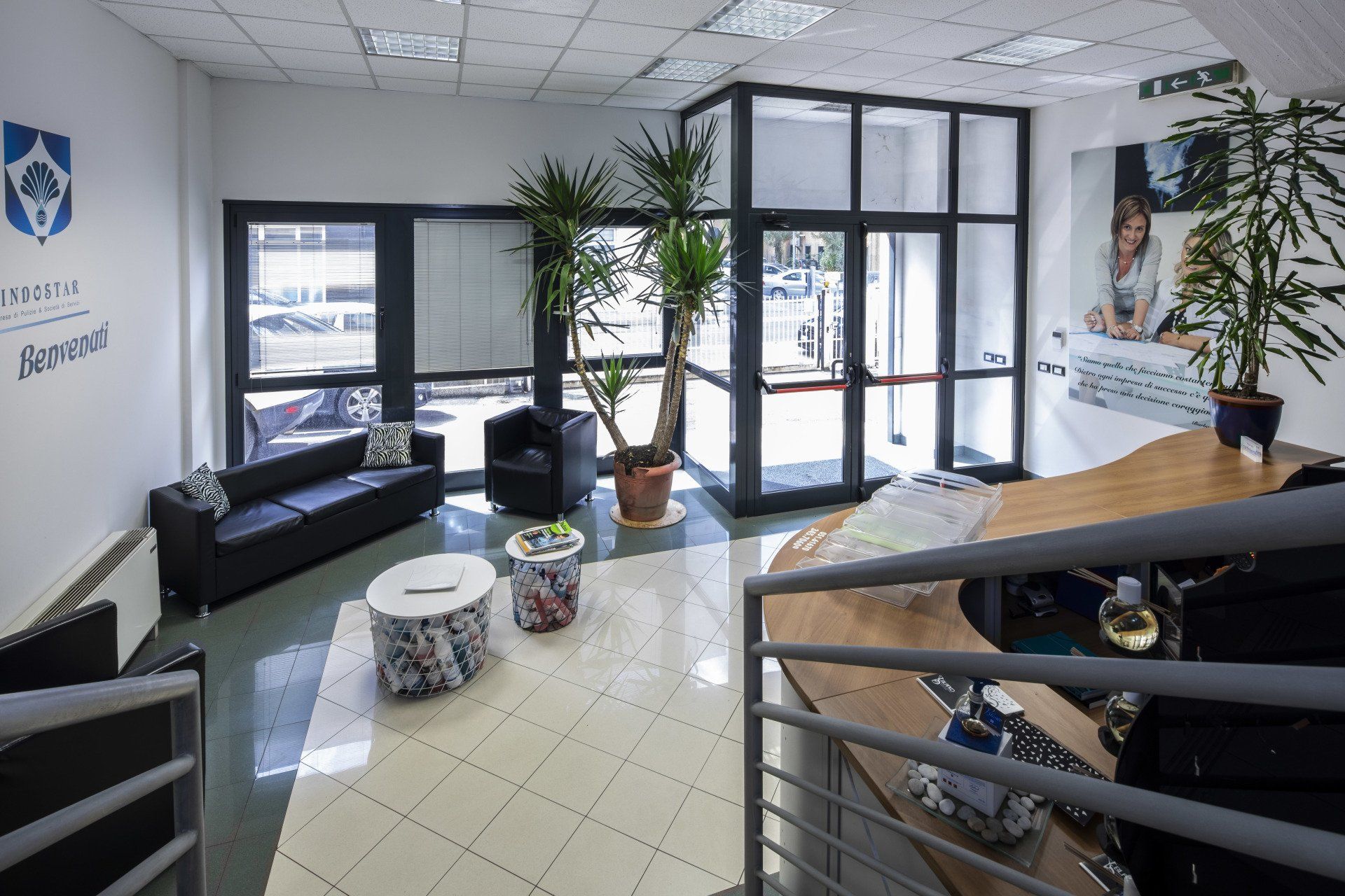 Una sala d'attesa con un divano, sedie, tavoli e una scrivania