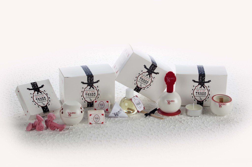 Una fila di bottiglie di profumo e candele su una superficie innevata