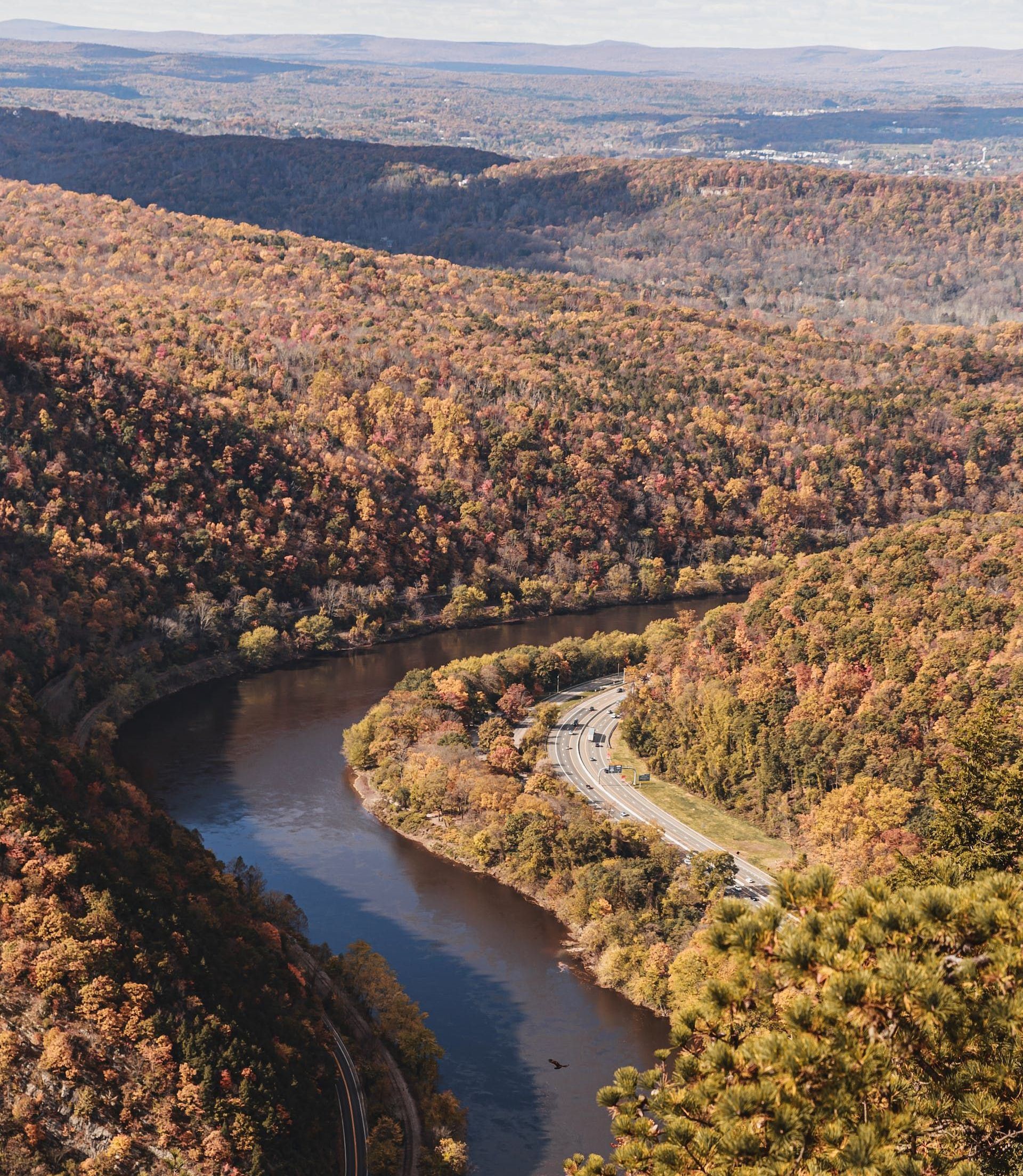 An aerial view of a river surrounded by trees and mountains