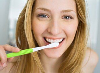 Woman brushing her teeth — Dentistry in Baltimore, MD