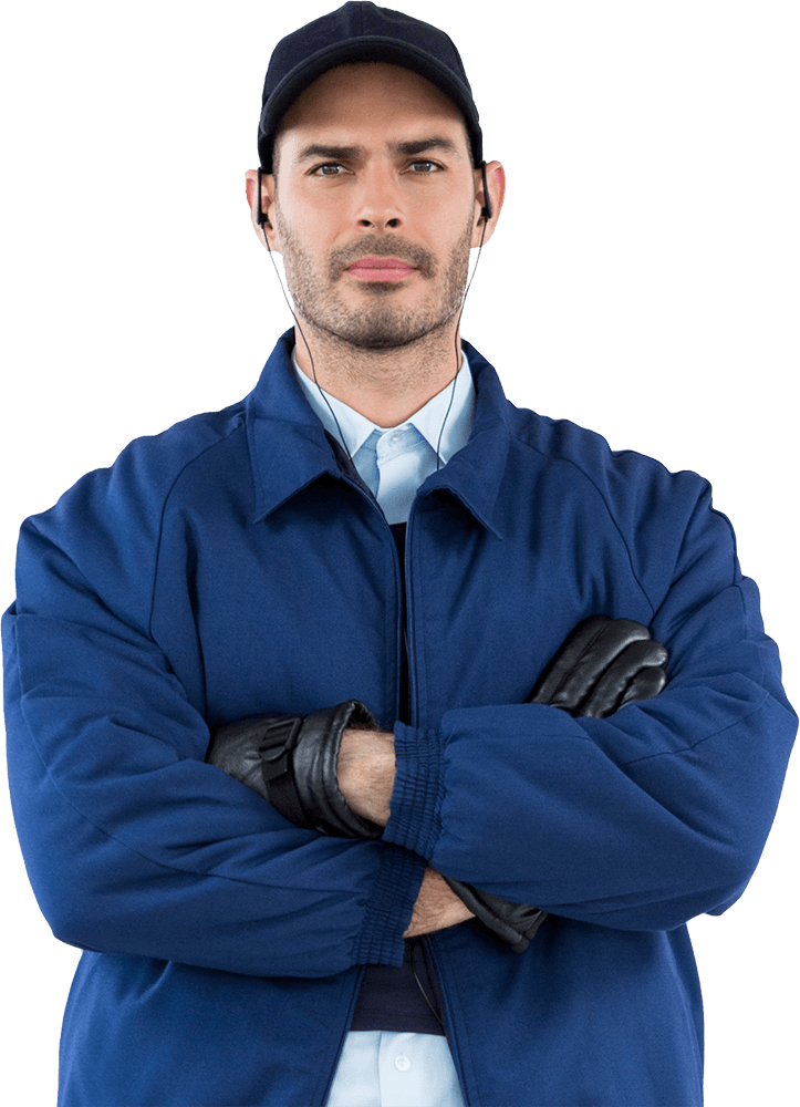 Man in blue work uniform with crossed arms, wearing a hat, gloves, and earbuds.