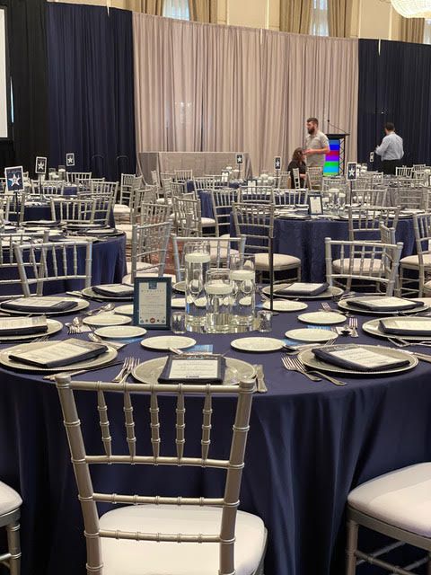 A large room with tables and chairs set up for a party