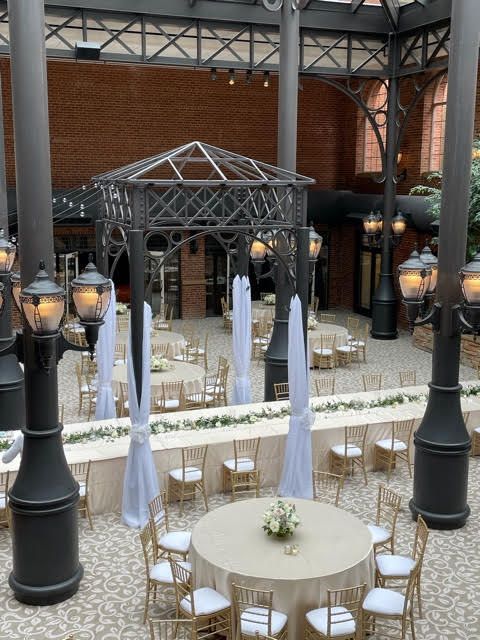 A large room with tables and chairs set up for a wedding reception