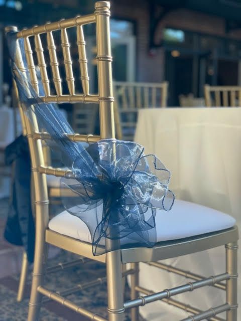 A row of wooden chairs decorated with wreaths and ribbons.