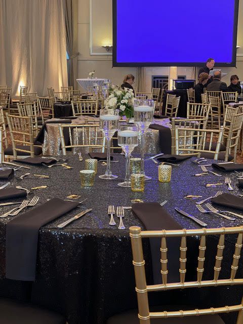 A large room with tables and chairs and a large screen