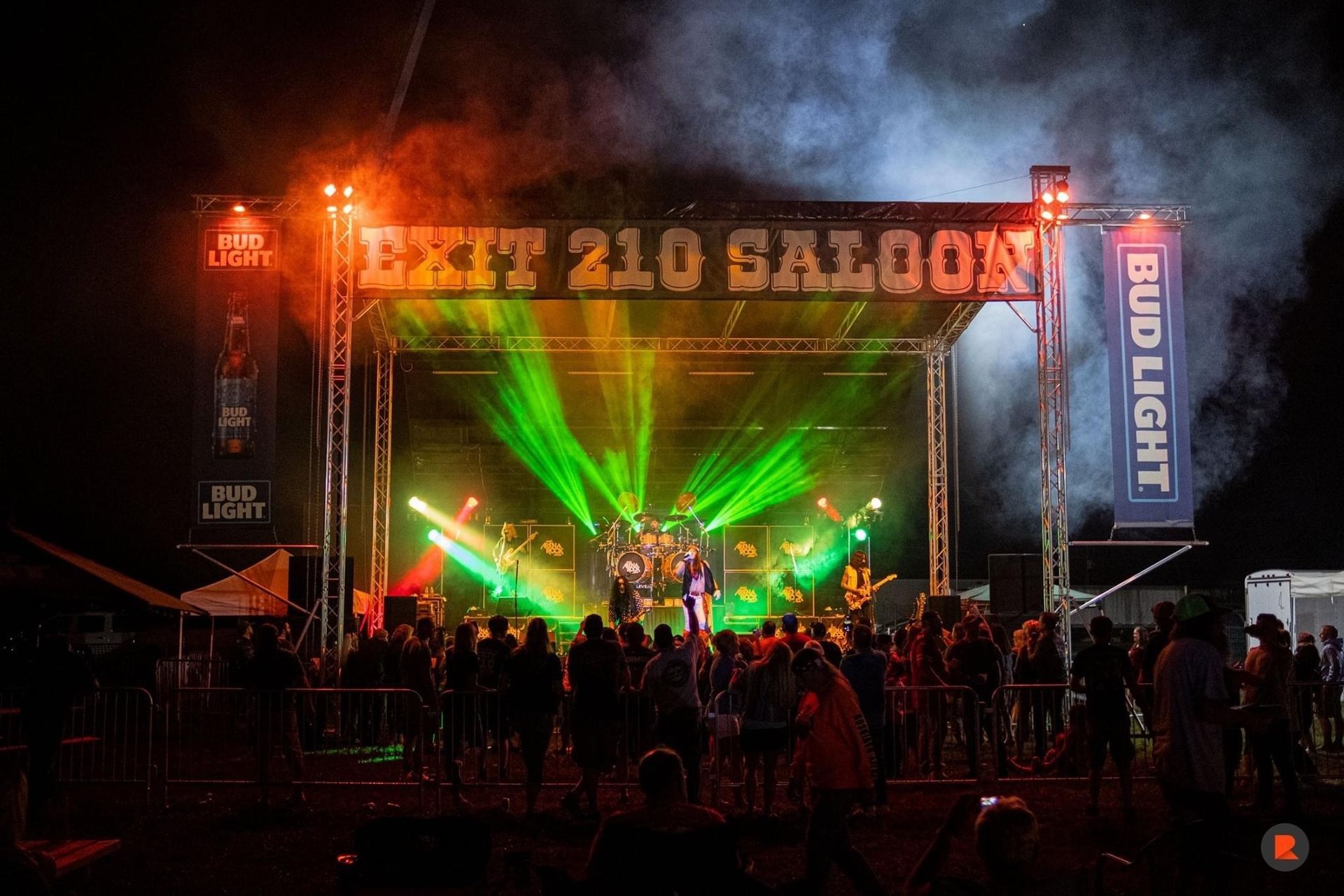 A band is playing on a stage with a sign that says exit 210 270