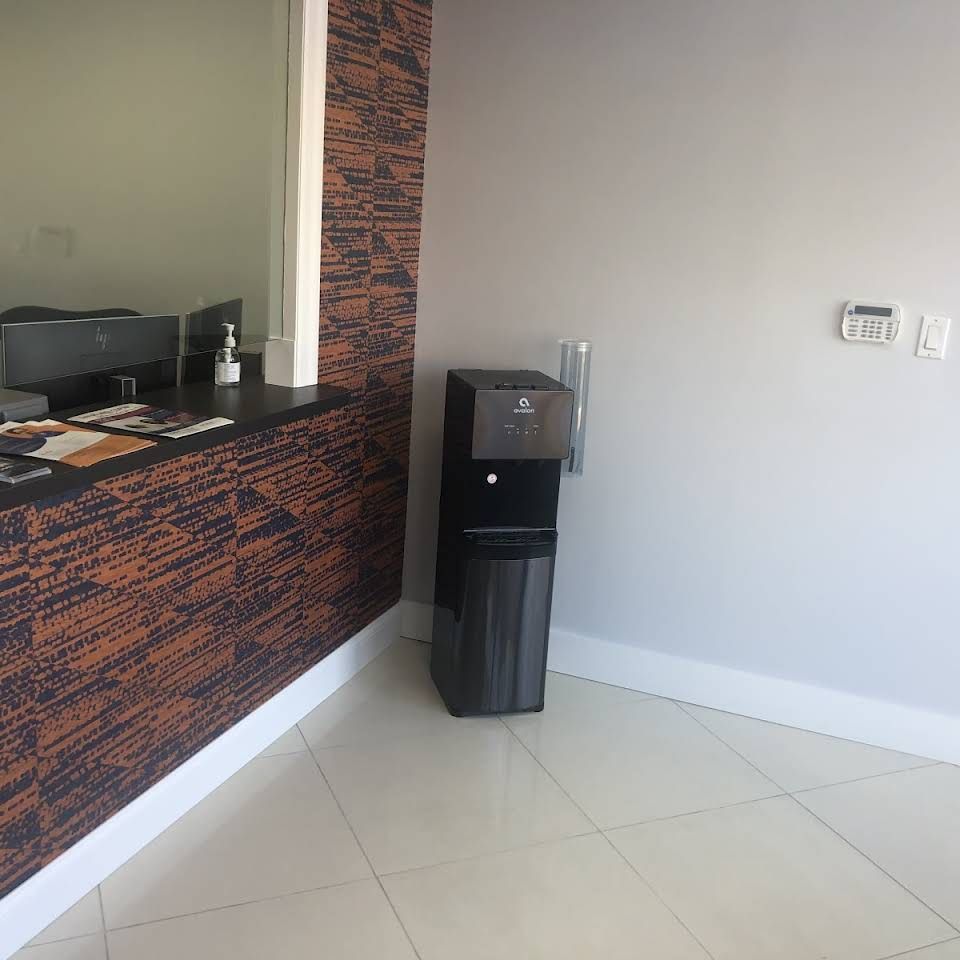 A black water dispenser sits in a room next to a counter