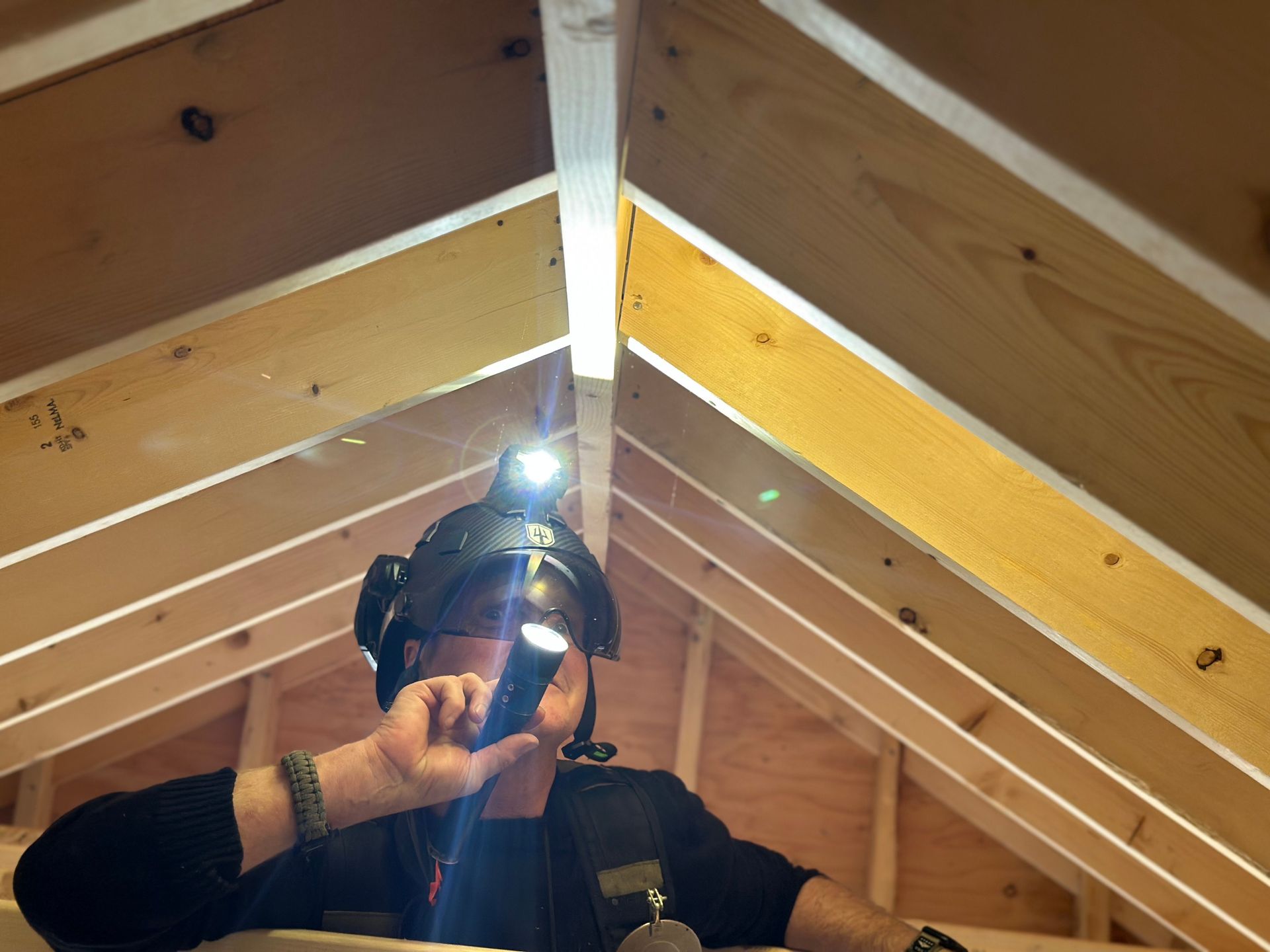 A man wearing a helmet with a flashlight on his head