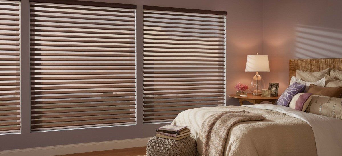 a bedroom with a bed and alta blinds on the windows Love is Blinds Missouri (314) 808-3440.