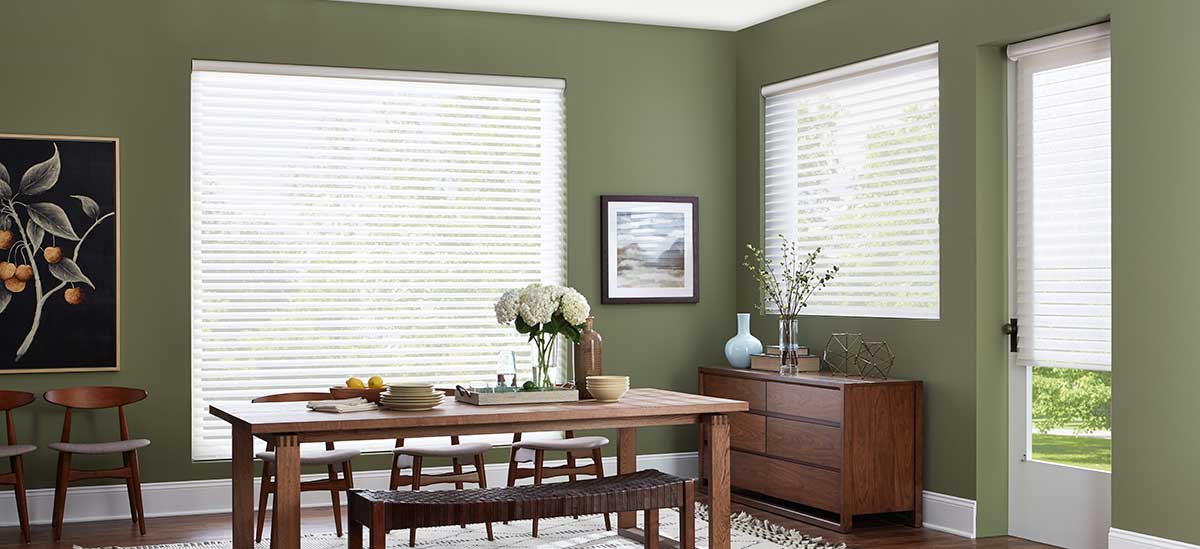 a dining room with green walls , white alta blinds , a wooden table and chairs Love is Blinds Missouri (314) 808-3440.