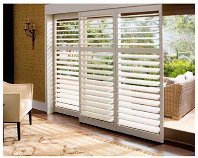 Love is Blinds St. Louis: A living room with a sliding glass door with white shutters on it.