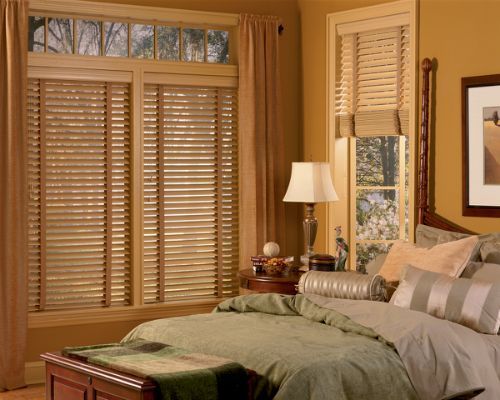 a bedroom with a bed and a window with blinds Love is Blinds Missouri (314) 808-3440