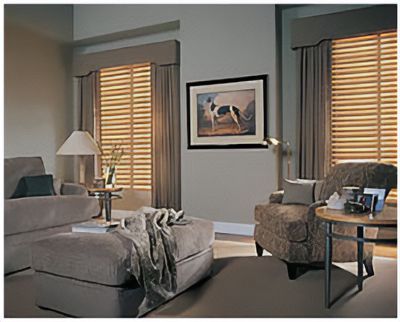 Love is Blinds St. Louis: A living room with a couch a chair, a table, and windows with tan blinds.