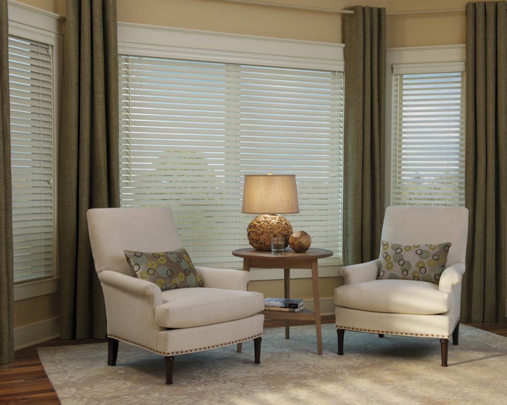 a living room with blinds, two chairs , a table and a lamp Love is Blinds Missouri (314) 808-3440.