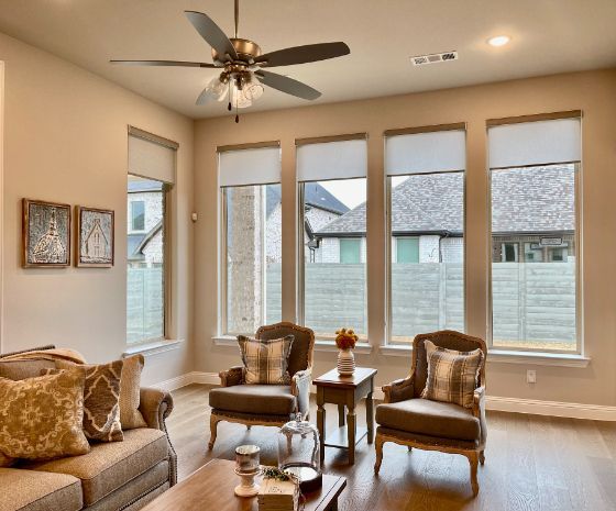 Love is Blinds MO: A living room with a ceiling fan and lots of windows with roller shades.