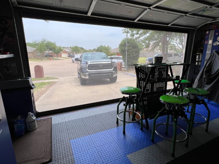 A garage with patio shades shows a transparent view of the driveway. 