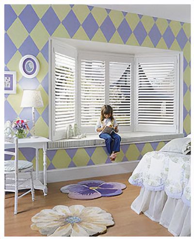 Love is Blinds MO: A little girl is sitting on a window with white plantation shutters.