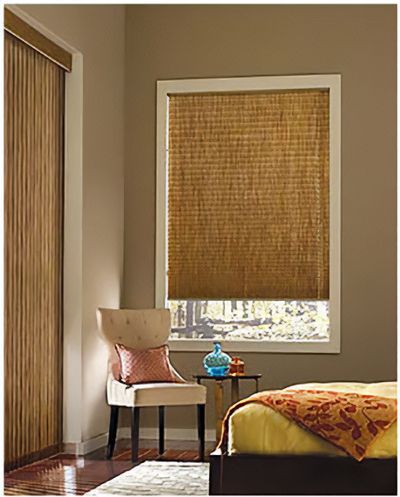 Love is Blinds St. Louis: A bedroom with a bed , chair , table and window with roller shades.