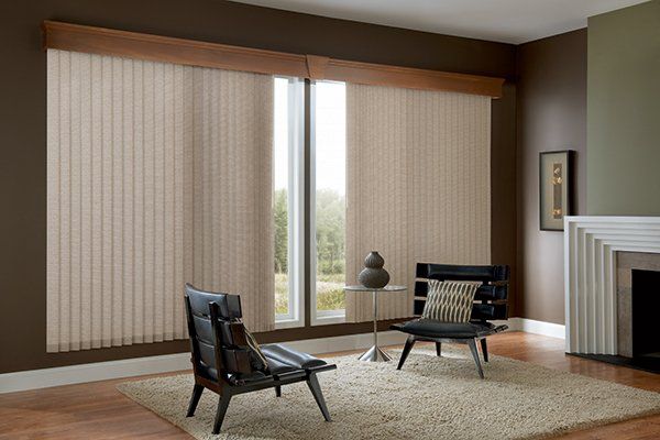 a living room with vertical shadings, a chair , a table and a fireplace Love is Blinds Missouri (314) 808-3440.