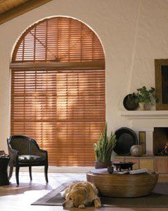 a living room with custom blinds, a dog laying on the floor and a fireplace Love is Blinds Missouri (314) 808-3440.