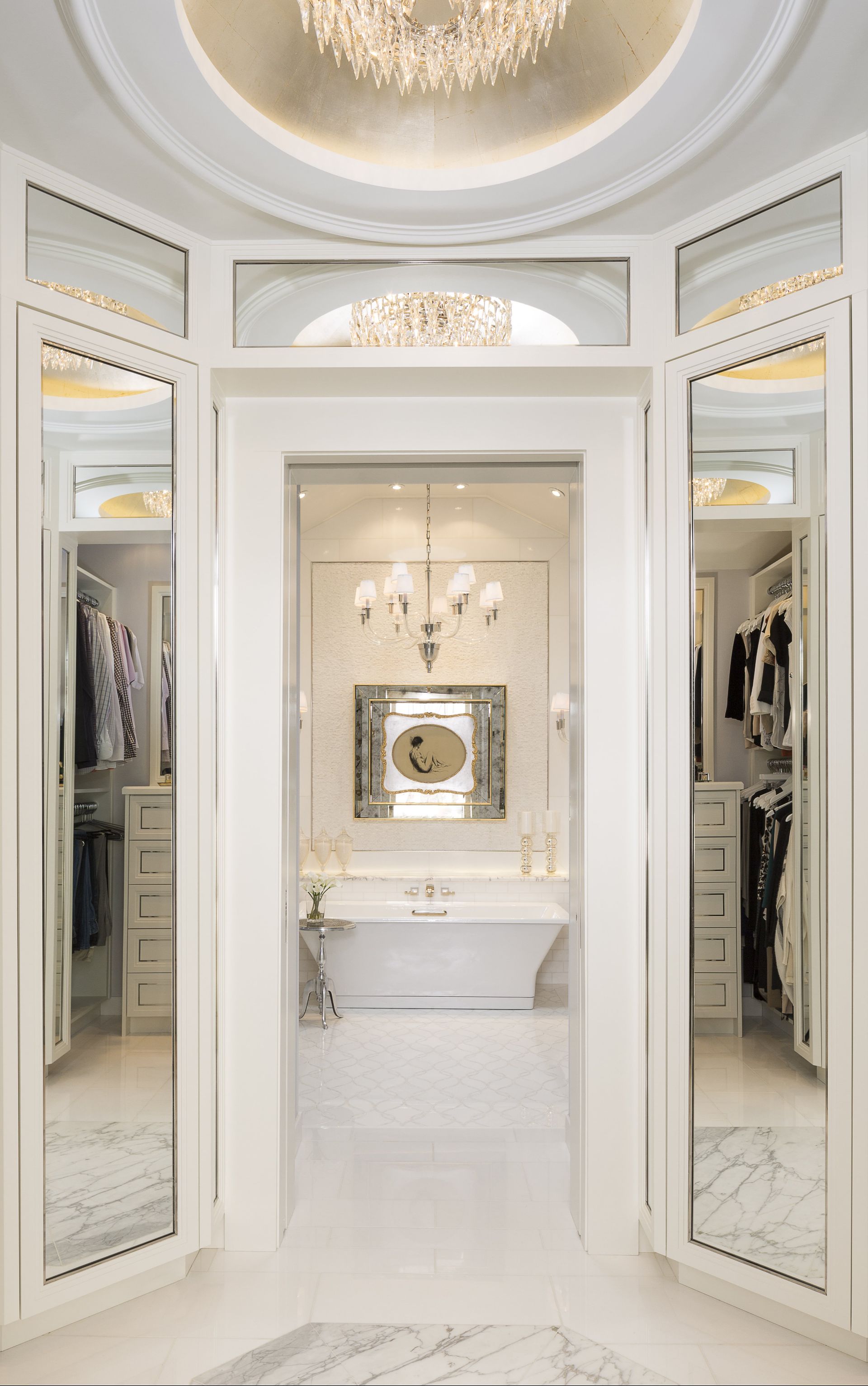 A walk in closet with a bathtub and a chandelier.