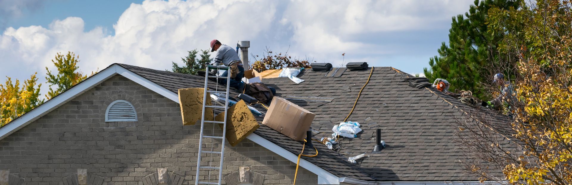 Professional contractors providing expert home roofing services on a residential asphalt roof. Professional contractors providing expert home roofing services on a residential asphalt roof.