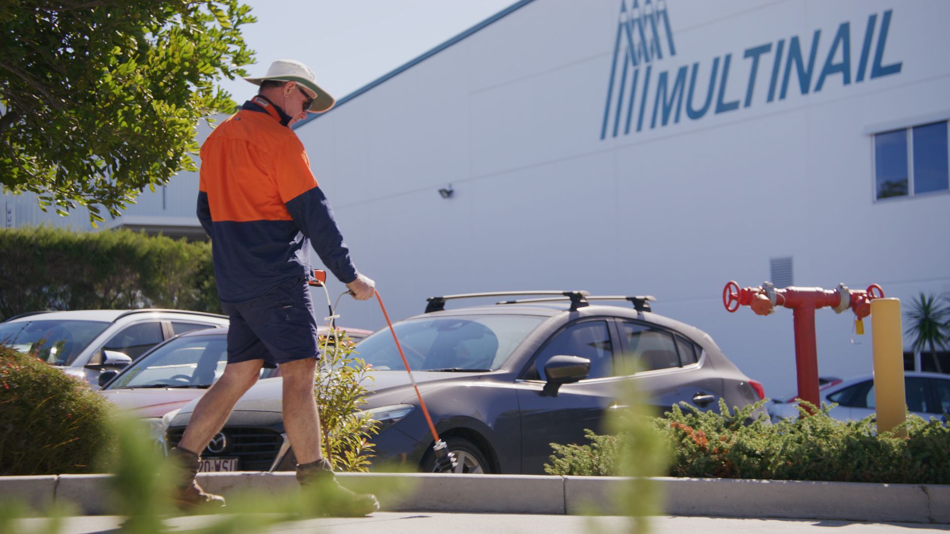 Construction Worker in Orange and Navy Uniform Walks — Commercial Leak Detection in South Brisbane, QLD