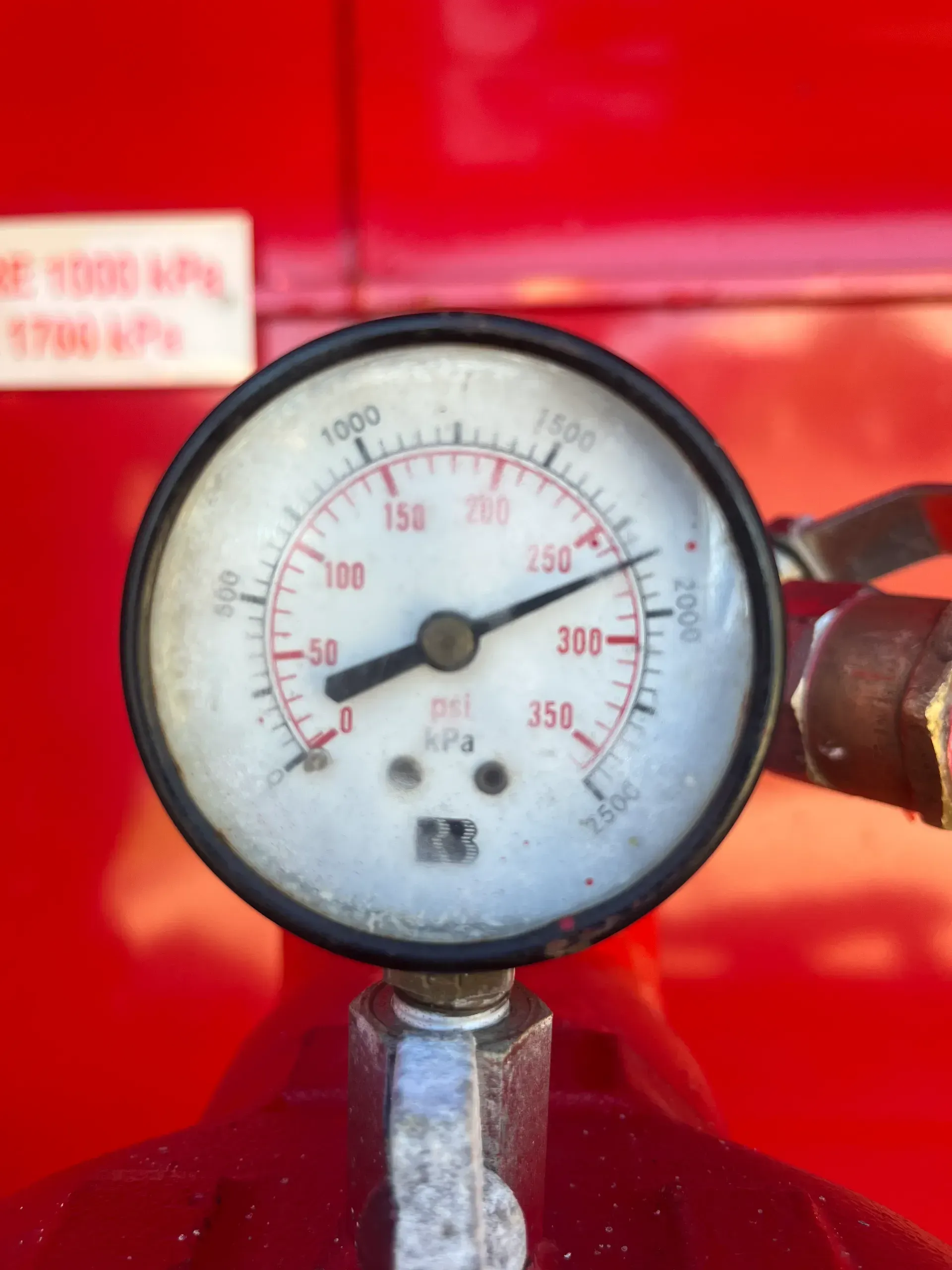 Pressure gauge with black frame against red background, reading approximately 250 psi or kPa.  — Commercial Leak Detection