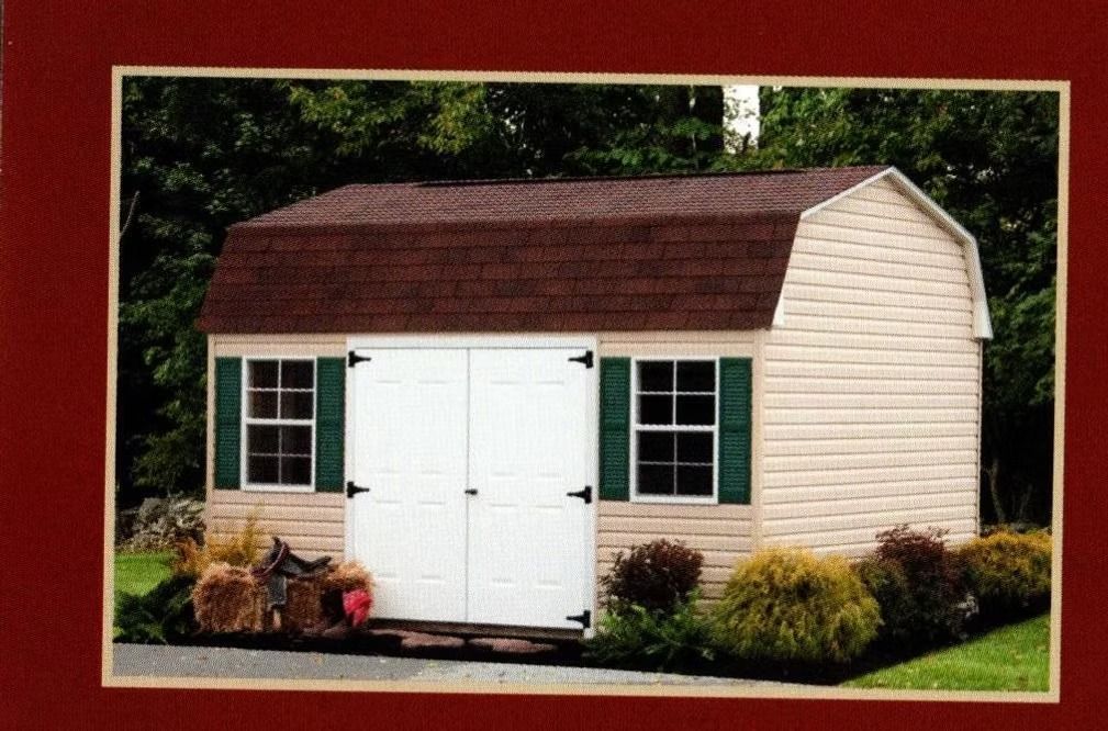 Small beige garden shed with white double doors, green shutters, and a brown roof in a landscaped yard