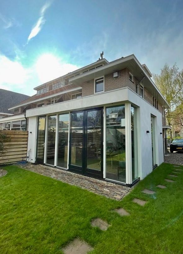 Een groot huis met veel ramen en veel gras ervoor.
