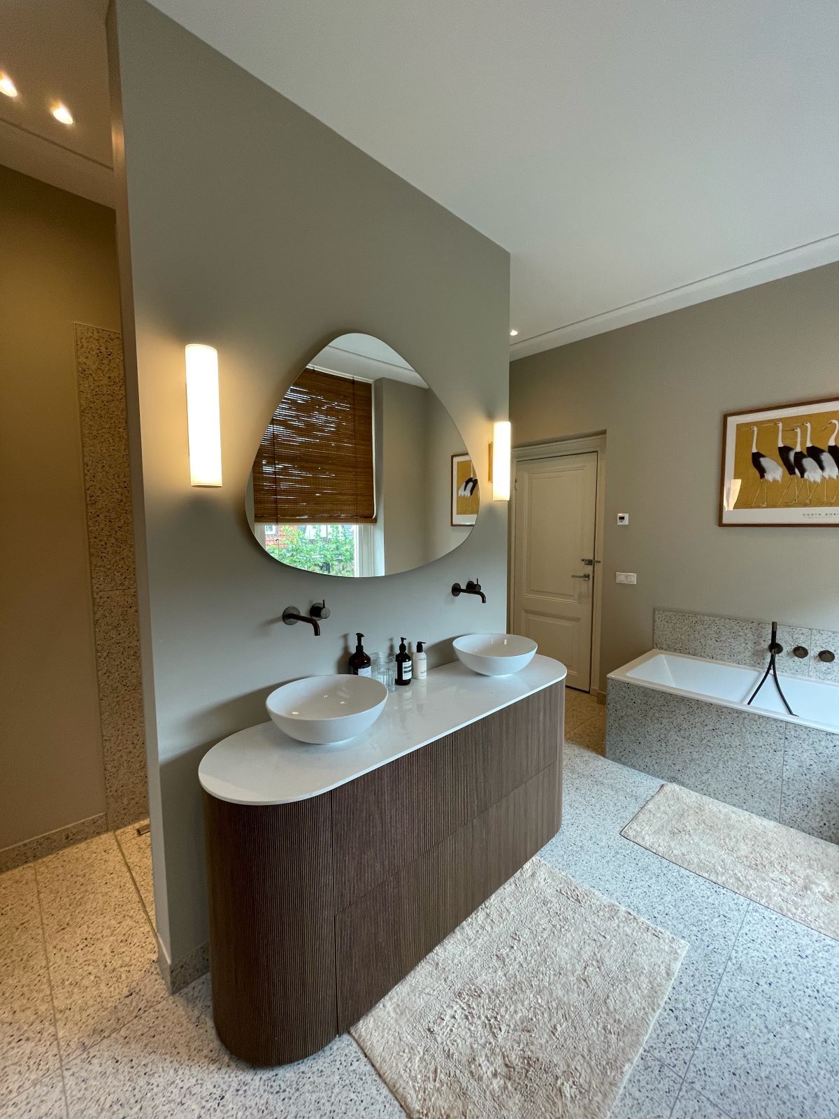 Een badkamer met twee wastafels en een grote spiegel.