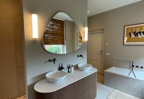 Een badkamer met twee wastafels en een grote spiegel.