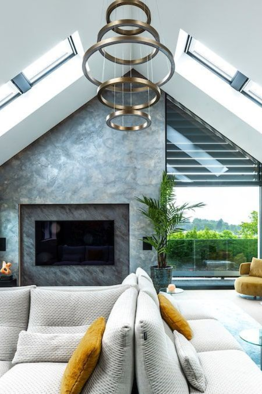 Een lege kamer met een gewelfd plafond en een groot raam.