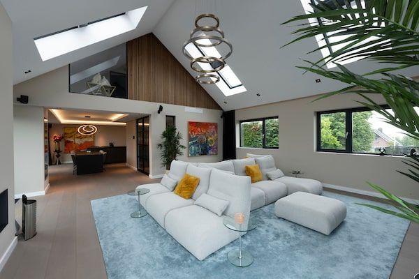 Een woonkamer met een witte bank en een blauw kleed