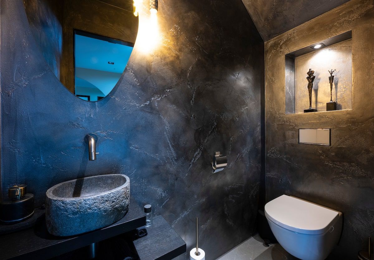 Een badkamer met wastafel, toilet en spiegel.