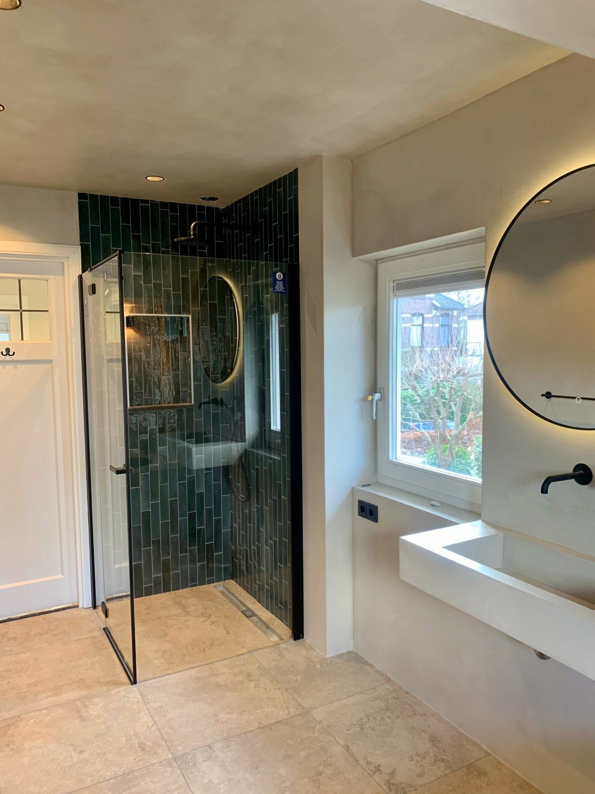 Een badkamer met wastafel, douche en spiegel.