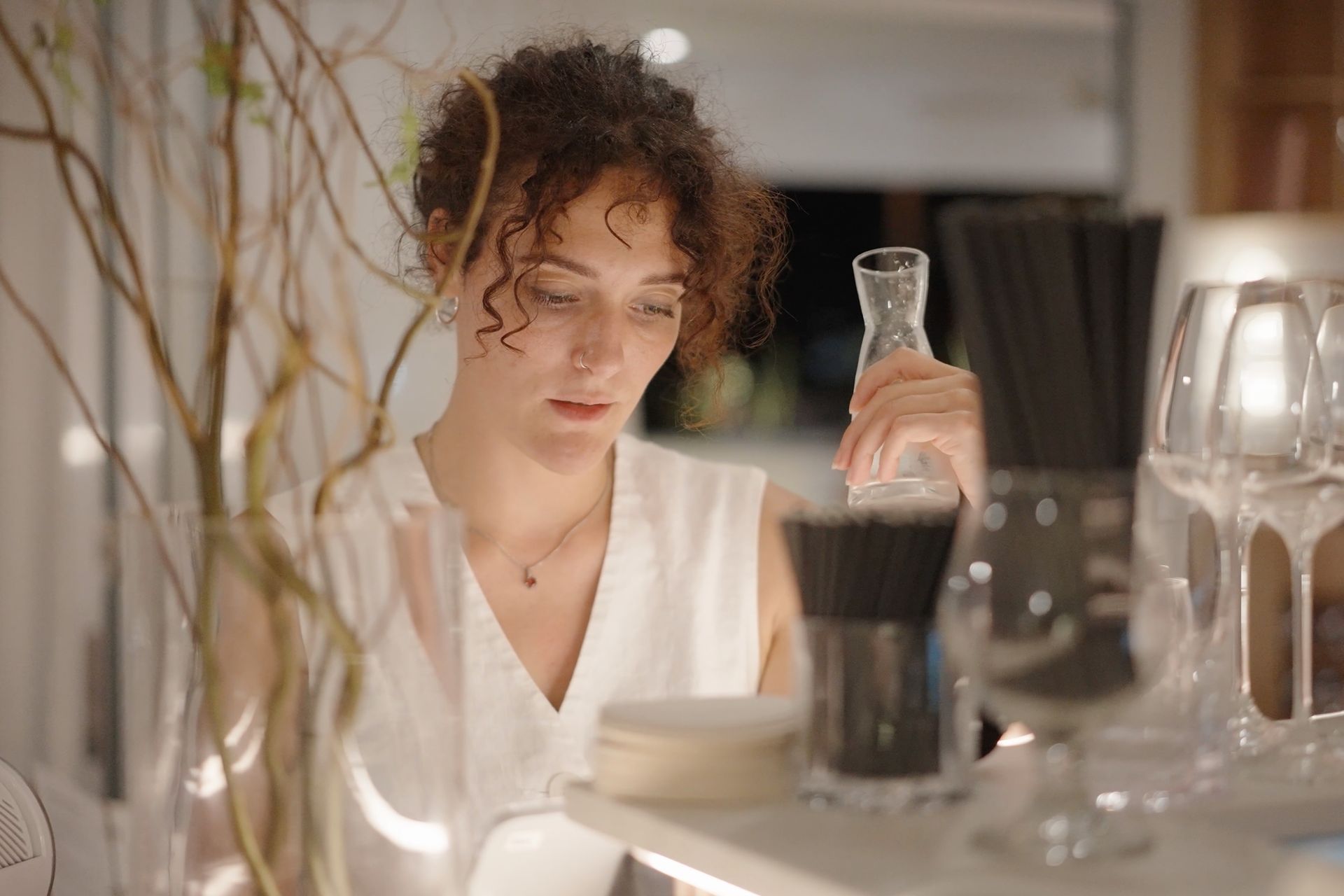 Restaurant employee holding water carafe while placing an order for a customer