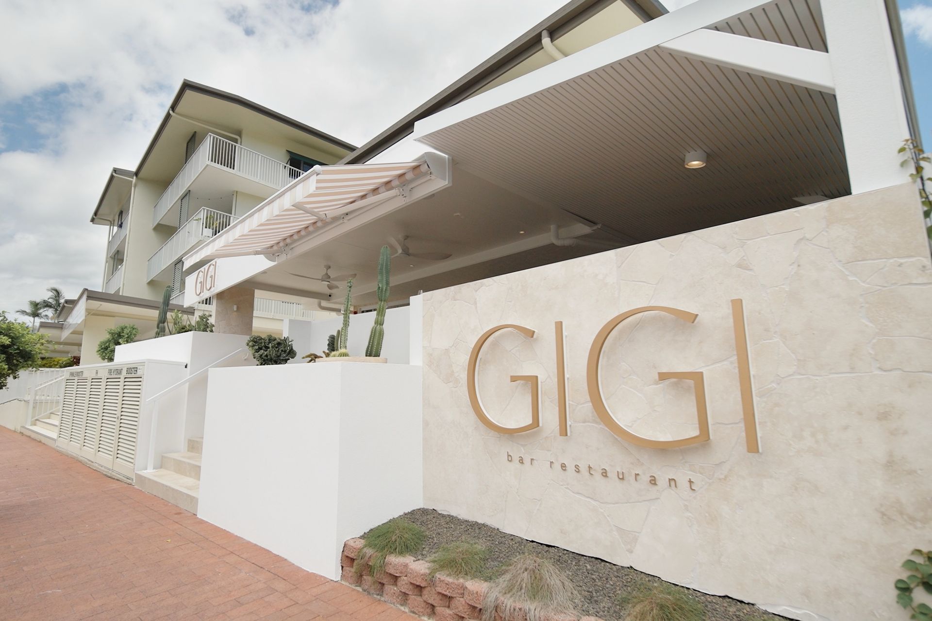 Exterior view of GiGi restaurant entry and façade from Collins Avenue