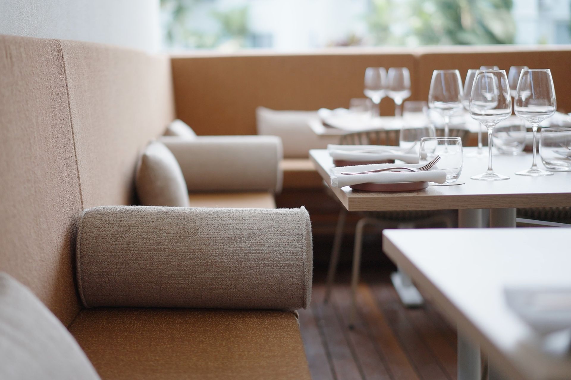Booth seating detail showing upholstery and custom bolster cushions with table setting